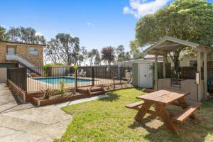 a backyard with a picnic table and a swimming pool at On The Beach in Rosebud