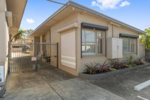 a small house with a gate in a parking lot at On The Beach in Rosebud