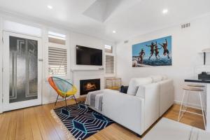 a living room with a white couch and a fireplace at On The Beach in Rosebud