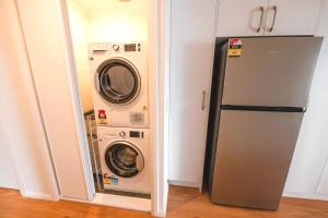 a washer and dryer in a kitchen next to a refrigerator at Blue Lagoon Beach Resort in The Entrance