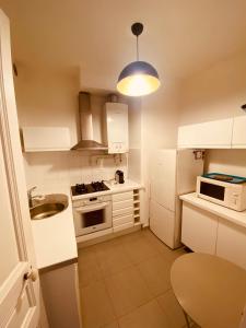 a small kitchen with white cabinets and a blue light at Monaco border villa Maria in Beausoleil