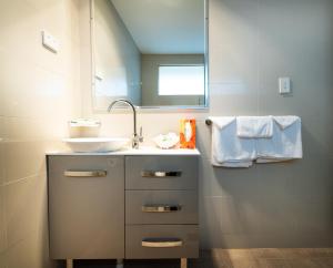 a bathroom with a sink and a mirror at River Motel in Queanbeyan +110 photos