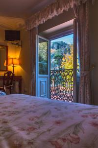 a bedroom with a bed and a large window at Hotel Sintra Jardim in Sintra +37 photos