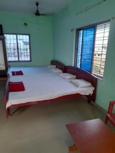 ein Schlafzimmer mit einem großen Bett in einem Zimmer mit Fenstern in der Unterkunft Goroomgo Star Inn Digha Near Sea Beach - Lift & Parking Facilities - Best Seller in Digha
