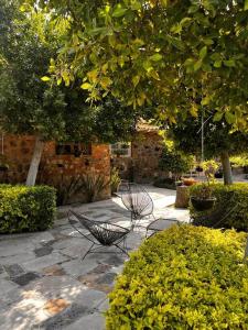 dois bancos sentados num pátio de pedra num jardim em Casa Corazón em Celaya