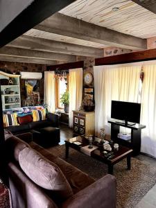 uma sala de estar com um sofá e uma televisão em Casa Corazón em Celaya