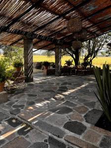 a patio with a wooden pergola and tables and plants at Casa Corazón in Celaya