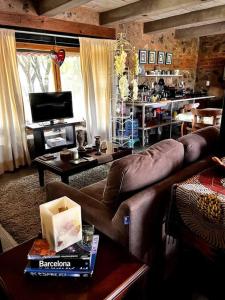 uma sala de estar com um sofá de couro e uma televisão em Casa Corazón em Celaya