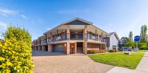 a large house with a balcony on a street at River Motel in Queanbeyan