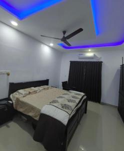 1 dormitorio con 1 cama con techo azul en Rain Homestay, en Alleppey