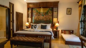 a bedroom with a bed with a painting on the wall at Cheva Gallery Boutique Hotel in Chiang Mai