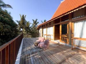 a deck of a house with a bench on it at Diamond Beach Villas in Nusa Penida