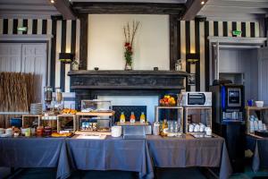 a room with a table with food and a fireplace at La Villa Andry in Ouistreham +37 photos