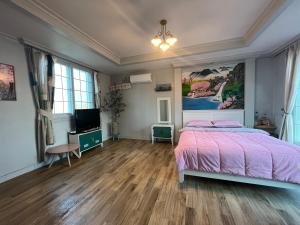 1 dormitorio con 1 cama y TV en Artist and Flower Pension, en Namhae