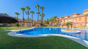 una piscina in un cortile con palme di Chalet Islantilla Costa de la Luz Isla Cristina by Ruralidays a Isla Cristina