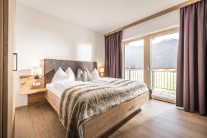 a bedroom with a bed and a large window at Zeit.Glück Appartements in Radfeld