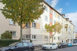 un groupe de voitures garées devant un bâtiment dans l'établissement Modernes Apartment – 2 Boxspringbetten – Zentral, à Cassel