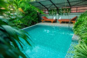 una grande piscina con due panchine di Mohasal Angkor Boutique a Siem Reap