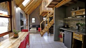 a kitchen with a wooden table and a staircase at Little Forest Farm in Magaliesburg