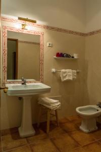 a bathroom with a sink and a toilet and a mirror at Hotel Sintra Jardim in Sintra