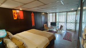 a bedroom with a large bed and a table with chairs at Mcleodganj Bed & Breakfast in McLeod Ganj