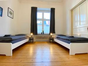 two beds in a room with a window at Work & Stay Apartments in Rheine in Rheine