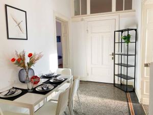 a dining room with a white table and white chairs at Work & Stay Apartments in Rheine in Rheine