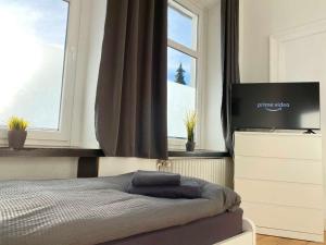 a bedroom with a bed with a flat screen tv at Work & Stay Apartments in Rheine in Rheine