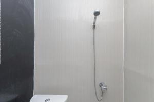 y baño con ducha con cabezal de ducha. en RedDoorz near Mayapada Hospital Surabaya, en Surabaya