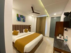 a bedroom with a large bed and a ceiling fan at Hotel Shiva Yog Sthal in Rishīkesh