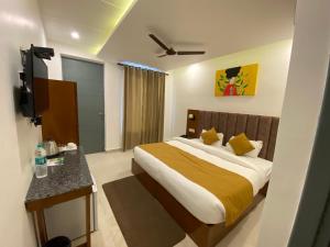 a hotel room with a bed and a television at Hotel Shiva Yog Sthal in Rishīkesh