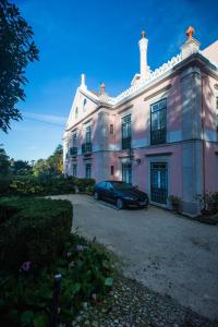 a car parked in front of a large house at Hotel Sintra Jardim in Sintra