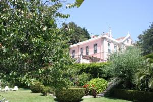 uma casa rosa com um jardim em frente em Hotel Sintra Jardim em Sintra