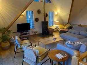 a living room with couches and chairs and a tv at Sandy Hills 8 in Padstow