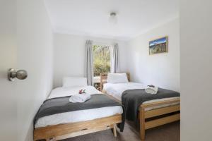 2 camas individuales en una habitación con ventana en Alencon en Blackheath