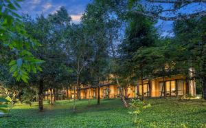 a building with trees in front of it at Klov Resort & Spa in Wayanad