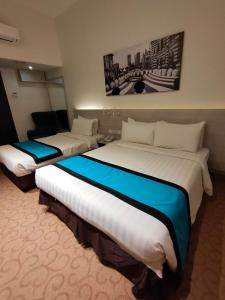 a hotel room with two large beds in it at EDC Hotel Kuala Lumpur in Kuala Lumpur