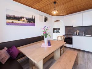 una cocina con una mesa de madera con flores. en Adults only apartment with pool, en Wasserhofen