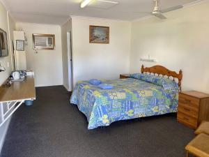 ein Schlafzimmer mit einem Bett und einer Kommode darin in der Unterkunft Minnipa Hotel in Minnipa