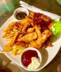 a plate of food with french fries and ketchup at Mama's Family Guesthouse in Kampot