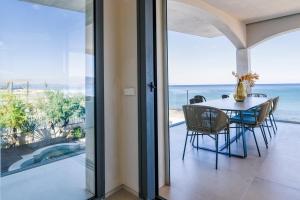 ein Esszimmer mit Tisch und Blick auf das Meer in der Unterkunft BEACH NEST VILLA in Son Serra de Marina