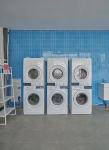 3 Waschmaschinen sowie eine Waschmaschine und ein Trockner in einem Zimmer in der Unterkunft M Village Lê Văn Sỹ in Ho-Chi-Minh-Stadt