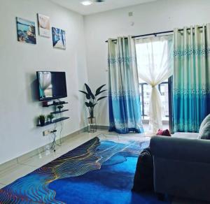 a living room with a couch and a blue rug at Zanra Homestay at Residensi Zamrud Blok B in Kajang