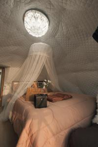 a bedroom with a bed in a tent with a chandelier at Skypruek Luu Hlee ลุฮลี in Mon Jam