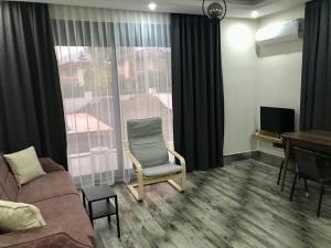 a living room with a couch and a table and a window at Tanem Suit in Kemer