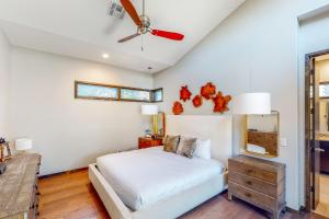 een slaapkamer met een bed en een plafondventilator bij Riverbend Cabin #015 in Spicewood
