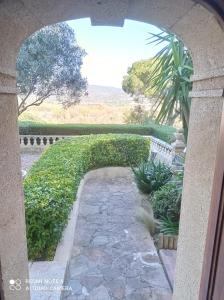 Blick auf einen Garten durch einen Torbogen in der Unterkunft Villa Domaine Font Mourrier in Cogolin
