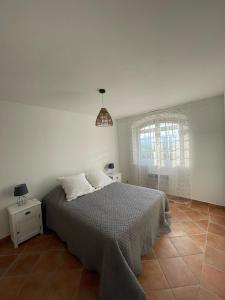 ein weißes Schlafzimmer mit einem Bett und einem Fenster in der Unterkunft Villa Domaine Font Mourrier in Cogolin