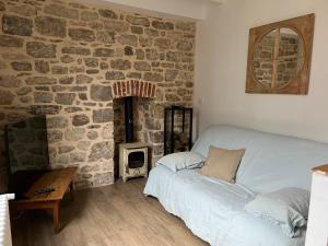 a bedroom with a bed and a stone wall at Appartement de charme en cœur de ville in Guingamp