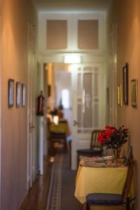 a hallway of a home with a table with flowers on it at Hotel Sintra Jardim in Sintra